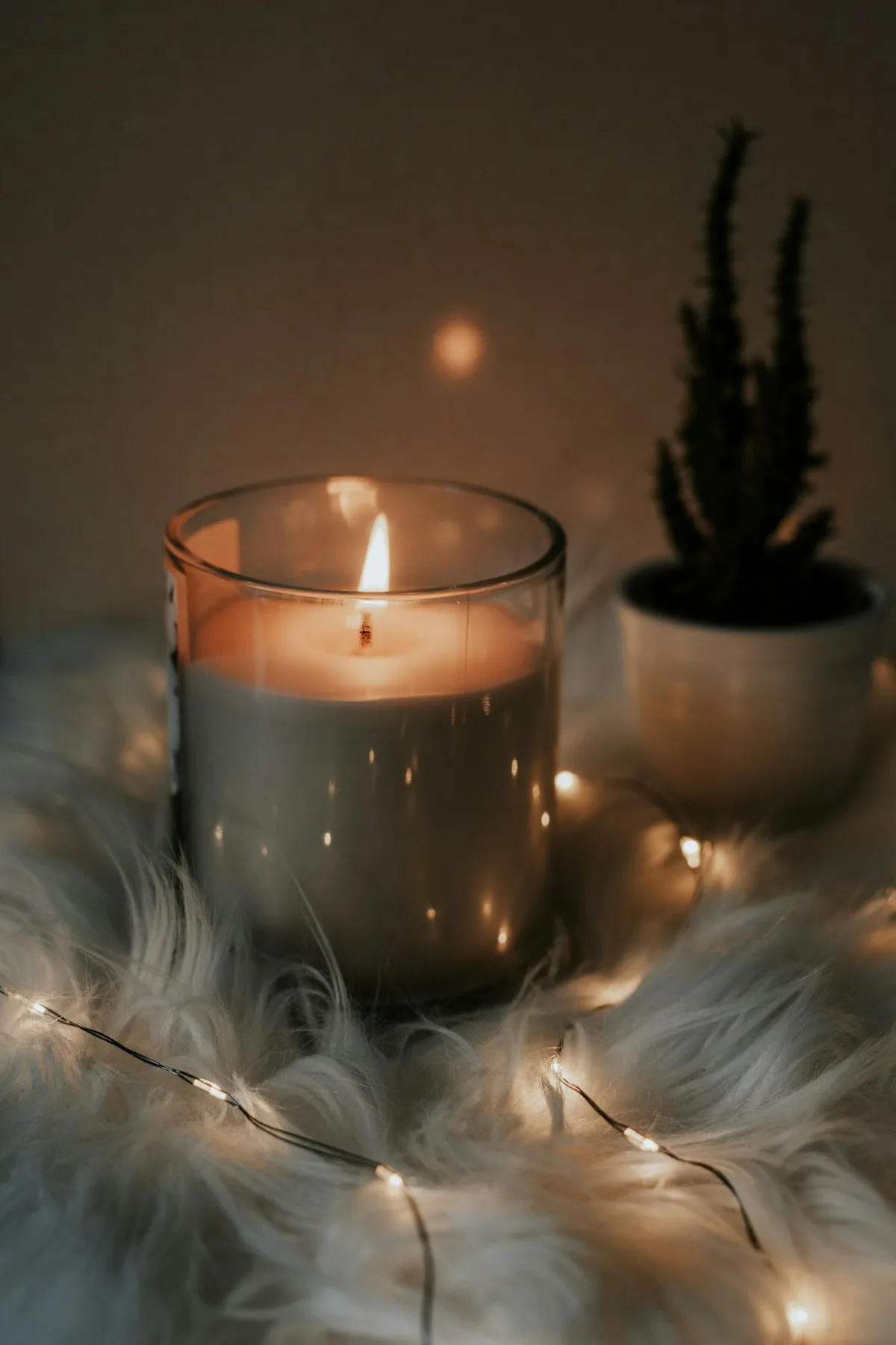 A lit candle beside a journal in a calm room